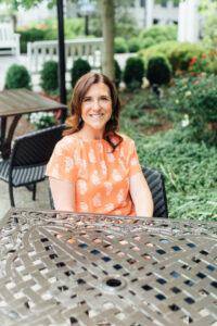 Robyn Marie, certified life coach for women and teens, smiling while seated outdoors—offering compassionate support for confidence and personal growth.